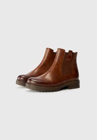 Bottines en cuir marron avec un panneau élastique sur les côtés, une languette de tirage et une semelle en caoutchouc texturée, présentant un bout arrondi et des détails cousus.