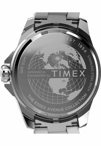 Zegarek ze stali nierdzewnej z okrągłą tarczą, na której znajduje się wzór globu w jasnoszarym kolorze. Grawerowane napisy zawierają "TIMEX" oraz "KOLEKCJA ESSEX AVENUE."