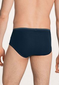 Donker marineblauwe herenboxers gemaakt van een gladde stof, met een comfortabele elastische tailleband met een contrasterend streepdesign.