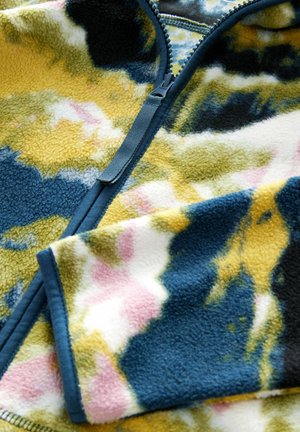 Fleece-ärmarjacka med ett flerfärgat abstrakt mönster i blått, gult och rosa. Har en mjuk textur och kontrasterande dragkedja.
