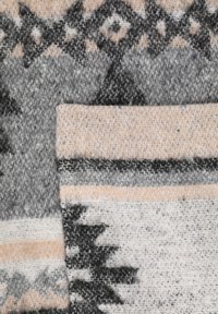 Patroontextiel met geometrische ontwerpen in zwart, grijs en beige kleuren. Zachte textuur met geweven details en afwisselende strepen.