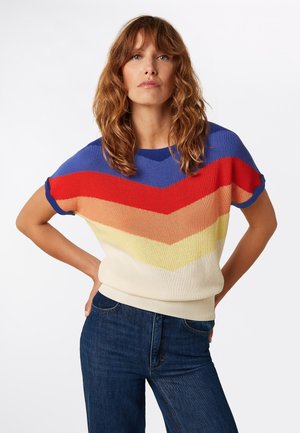 Kleurrijke gebreide trui met zigzagpatronen in blauw, rood, oranje, perzik, geel en crème, met korte mouwen en een ronde hals.