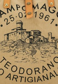 Bolsa de tela de algodón con fondo color canela, que presenta una ilustración negra de un castillo y un texto en negrita que detalla "Campo Maggio" y una fecha.