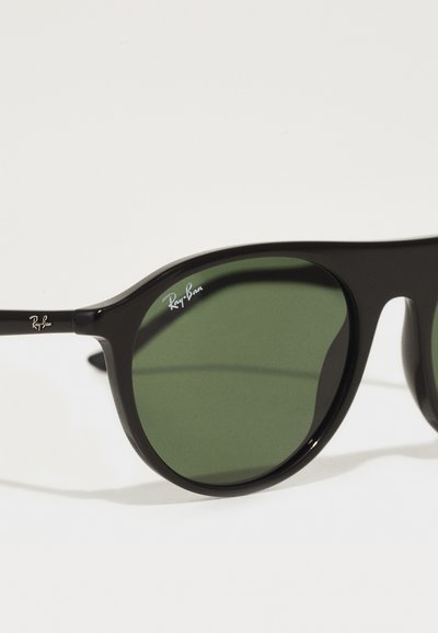 Черни слънчеви очила Ray-Ban с зелени стъкла, с гладка пластмасова рамка, кръгла форма и характерно лого на храмовете.