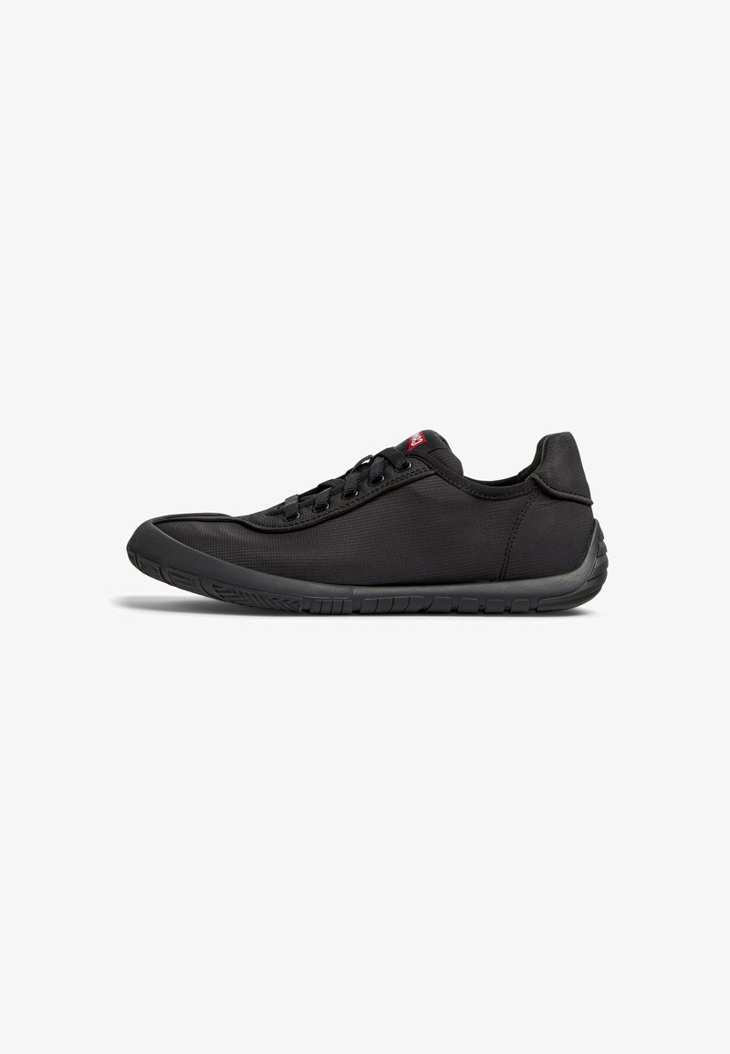 Black athletic shoes with a smooth fabric upper, rubber sole, six eyelets for laces, and a rounded toe design.