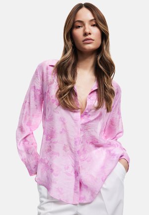 Camisa de manga larga rosa con un diseño floral, fabricada en un tejido ligero y translúcido. Tiene una parte frontal abotonada y un corte holgado.