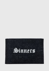 Črn pravokoten preproga z besedo "Sinners" v beli gotiki, ki je sredinsko postavljena.