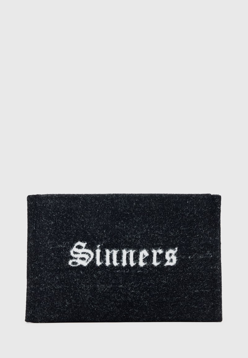 Črn pravokoten preproga z besedo "Sinners" v beli gotiki, ki je sredinsko postavljena.
