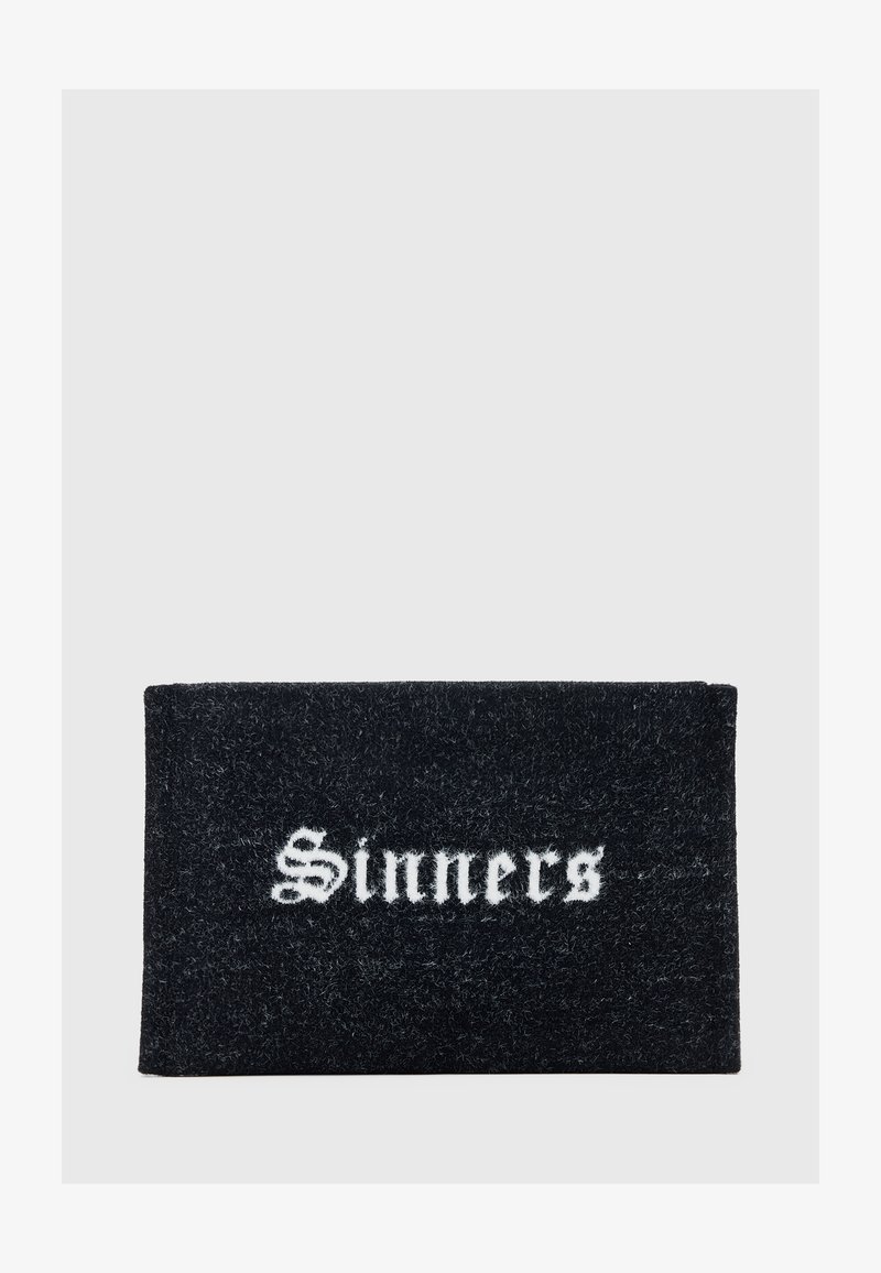 Czarny prostokątny wycieraczka z białym gotyckim napisem "Grzesznicy" wyśrodkowanym na gładkim szarym tle.