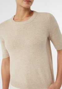 Beige trui met korte mouwen van zacht gebreid stof. Kenmerkt zich door een geribbelde ronde hals en geribbelde manchetten, met een soepele, casual uitstraling.
