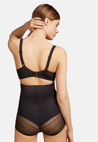 Faja negra con cintura alta, tirantes ajustables y detalles de encaje en la parte posterior. Textura suave con un diseño entallado.