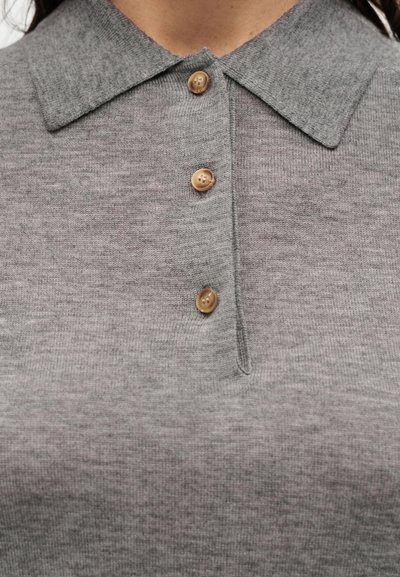 Polo gris en tricot avec un col classique et trois boutons beiges au niveau de l'encolure. Texture douce avec un motif subtil.
