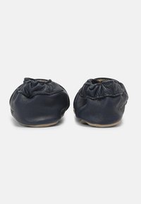 Scarpe in pelle blu navy con un design arricciato nella parte superiore, texture morbida e suola chiara. Nessuna ferramenta o accenti visibili.