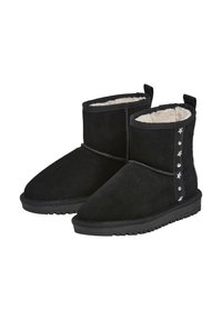 Stivaletti neri in suede con una morbida fodera in pelliccia, suola piatta e borchie decorative a forma di stella sul lato esterno.