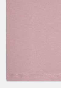 Tessuto di cotone rosa chiaro con una texture liscia, bordato e con dettagli di cucitura sottili. Design semplice a tinta unita.
