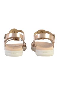 Sandali oro rosa con più cinturini, una soletta beige imbottita e una suola in gomma bianca. Include una fibbia regolabile alla caviglia per una vestibilità perfetta.