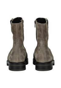 Bottes chelsea en suède gris avec une texture lisse, des zips sur le côté et des semelles en caoutchouc noir. Présente des coutures visibles le long des coutures.