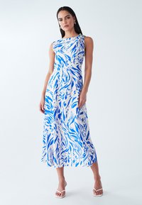 One-shoulder dress in a blue and white abstract print, featuring a textured fabric and a decorative accent at the shoulder.