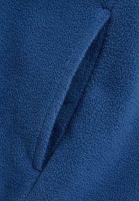 Blauwe fleece stof met een zachte, gestructureerde oppervlakte; bevat een naad en een gedeeltelijk zichtbare zakopening.