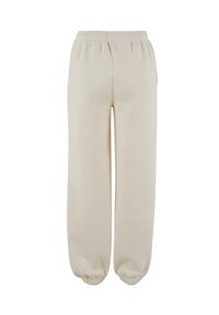 Beige sweatpants van zachte stof, met een elastische tailleband, zijzakken en elastische boorden bij de enkels.