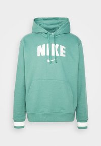 Zelená bavlněná mikina s velkým bílým logem "NIKE", kapucí na šňůrku, přední kapsou a pruhovanými manžetami v bílé a zelené barvě.