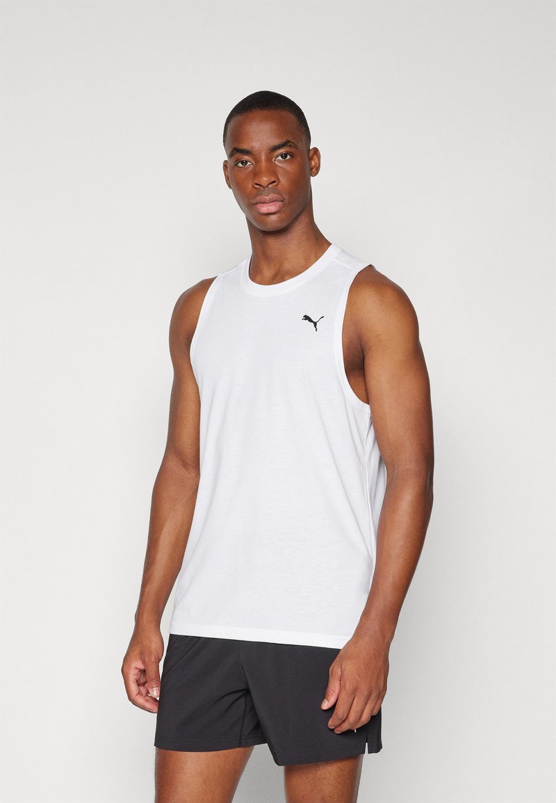 Débardeur blanc sans manches avec col rond, présentant un petit logo Puma noir sur le côté supérieur gauche. Tissu lisse et léger.