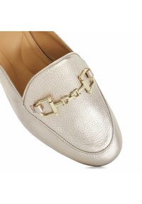 Metallische gouden loafers met een gestructureerde leren afwerking, voorzien van een gouden kettingaccent aan de voorkant en een gladde, ronde neus.