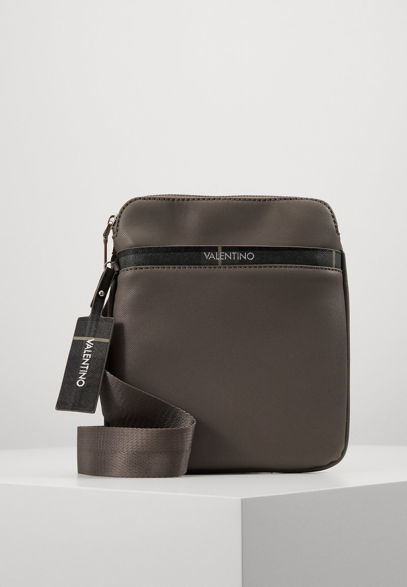 Gray nylon crossbody bag with a zip closure, flat design, adjustable strap, and a small tag featuring the brand name "Valentino."