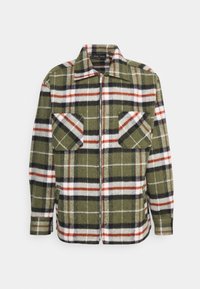 Zielona kurtka w kratę wykonana z miękkiego materiału, z zamkiem z przodu, ostrym kołnierzem oraz dwiema kieszeniami na piersi z kontrastowymi wzorami w bieli, czerni i czerwieni.