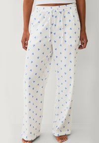 Witte pyjamabroek van een structuurstof, met een blauw hartjesprint, elastische tailleband met trekkoord en zijzakken.