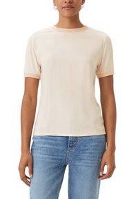 T-shirt a maniche corte in tessuto beige chiaro con una consistenza liscia, colletto girocollo e rifiniture in pesca chiaro a contrasto su maniche e colletto.