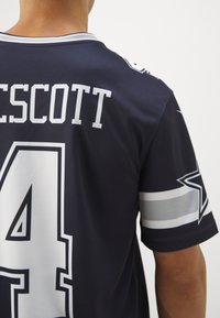 Dallas Cowboys mez sötétkék színben, fehér és ezüst kiegészítőkkel, hátul a "PRESCOTT" névvel és a "4"-es számmal.