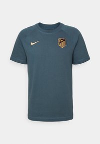 Camiseta deportiva de manga corta en teal oscuro con el logotipo naranja de Nike y el escudo del club de fútbol Atlético de Madrid en naranja y negro en el pecho.
