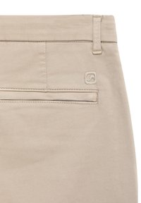 Beige Baumwollhose mit einer Gesäßtasche, die ein einfaches gesticktes Design aufweist, sowie einem kleinen gestickten Logo oberhalb der Tasche.
