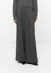 Grijze geruite wijde broek van een gestructureerde stof, met een elastische tailleband en een minimalistisch ontwerp. Gemaakt met een lange mouwtop.