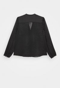 Blusa nera a maniche lunghe con motivo testurizzato, dotata di un colletto solido, dettaglio con schiena scoperta e accentuazioni con bottoni sulle maniche.