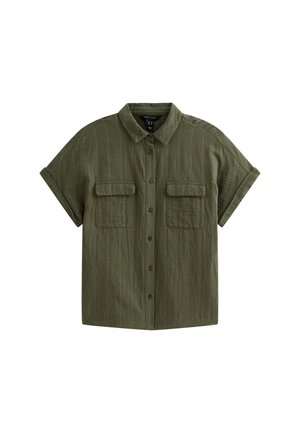 Chemise à manches courtes de couleur vert olive, en tissu texturé. Dotée d'un boutonnage à l'avant, de deux poches poitrine et d'un col classique.