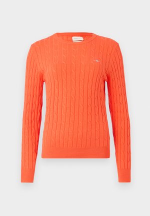 Πορτοκαλί πλεκτό πουλόβερ με νηματωτή μπούκλα, στρογγυλή λαιμόκοψη και ριμπ μανσέτες. Διαθέτει ένα μικρό λογότυπο στο στήθος.