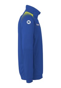 Veste de sport bleue avec un col haut. Présente des accents jaunes en dégradé sur l'épaule et un logo circulaire sur la manche gauche.