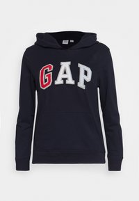Felpa navy con tasca a marsupio, caratterizzata dal logo "GAP" ricamato in multicolore, rosso, bianco e grigio. Materiale in morbido cotone.