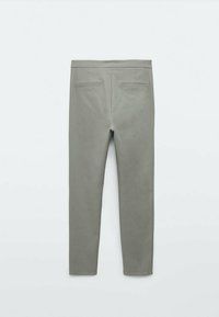 Pantalons slim fit en gris clair, avec une texture lisse, deux poches arrière et une taille. Le design est minimaliste et moderne.