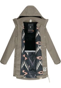 Beige ytterjakke med hette; indre fôr har et svart stoff med sikksakk-mønster i rosa og hvitt. Inkluderer merke på siden.