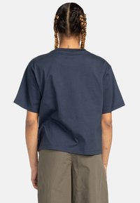 Navy blue cotton t-shirt with short sleeves, crew neck, and a relaxed fit. Features a smooth texture and minimalist design.