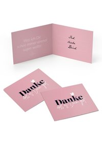 Rozā apsveikuma karte ar tekstu "Danke" treknā melnā fontā un ar roku rakstīts ziņojums iekšpusē. Ir redzamas divas kartes.