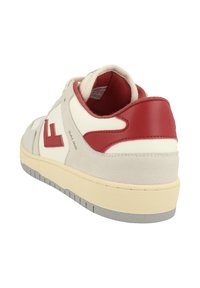 Bílé a šedé tenisky s červenými akcenty, vyrobené z velurové a syntetické kůže, s polstrovaným límcem a texturovanou gumovou podrážkou.