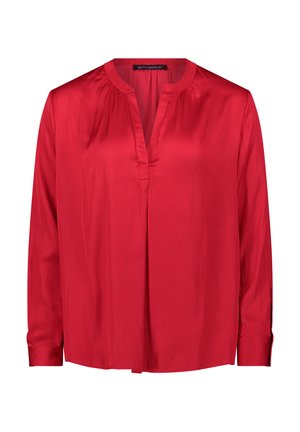 Blouse en soie rouge avec des manches longues, décolleté en V et plissés à l'avant. Texture lisse et coupe légèrement décontractée. Poignets boutonnés.