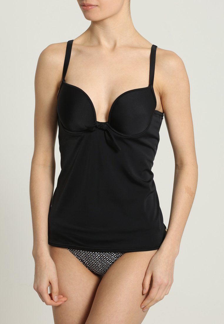 Top de tankini preto com copos moldados, alças ajustáveis e detalhe amarrado no centro. Apresenta uma textura suave, combinado com calções de biquíni estampados.