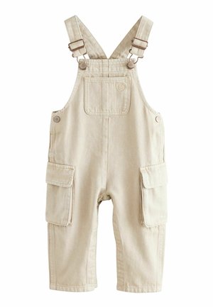Salopette in cotone beige con spalline regolabili, due tasche frontali e due tasche laterali cargo. Progettata con un tessuto durevole e testurizzato.