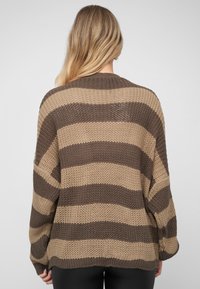 Brun- og beigestripet strikket genser med løs passform, vide ermer og en teksturert finish, med rund halsutringning og ribbestrikket kant.