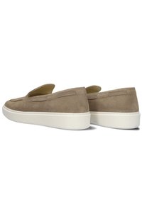 Beige suède instap schoenen met een laag profiel, voorzien van stikdetails aan de voorkant en een witte rubberen zool. Geen zichtbare branding.